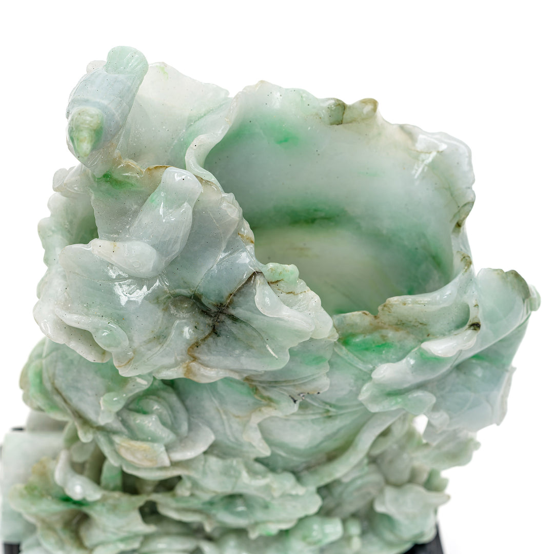 Exquisite jade carving with vines and ducks representing serenity.