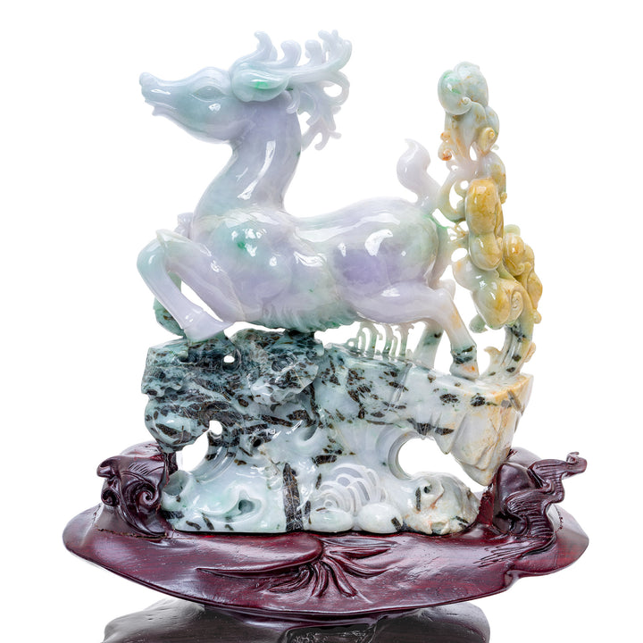 Pale green and lavender jade reindeer sculptures dashing through a rocky cliffside