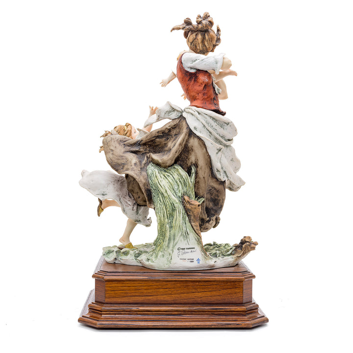 Artisanal porcelain figurine of joyful embrace from Italy.
