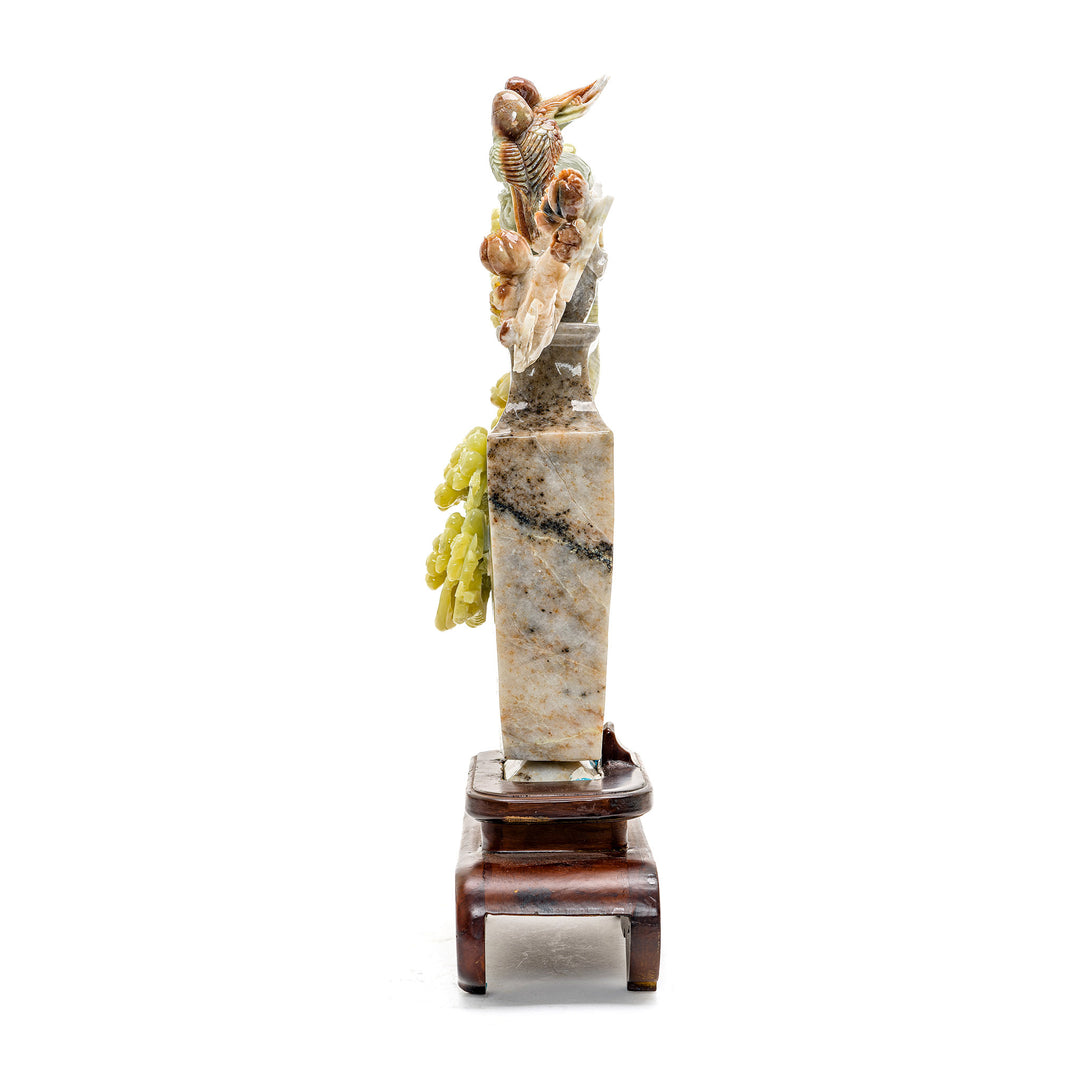 Intricate agate carving of plum blossoms branching from a vase.