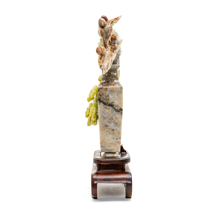 Intricate agate carving of plum blossoms branching from a vase.