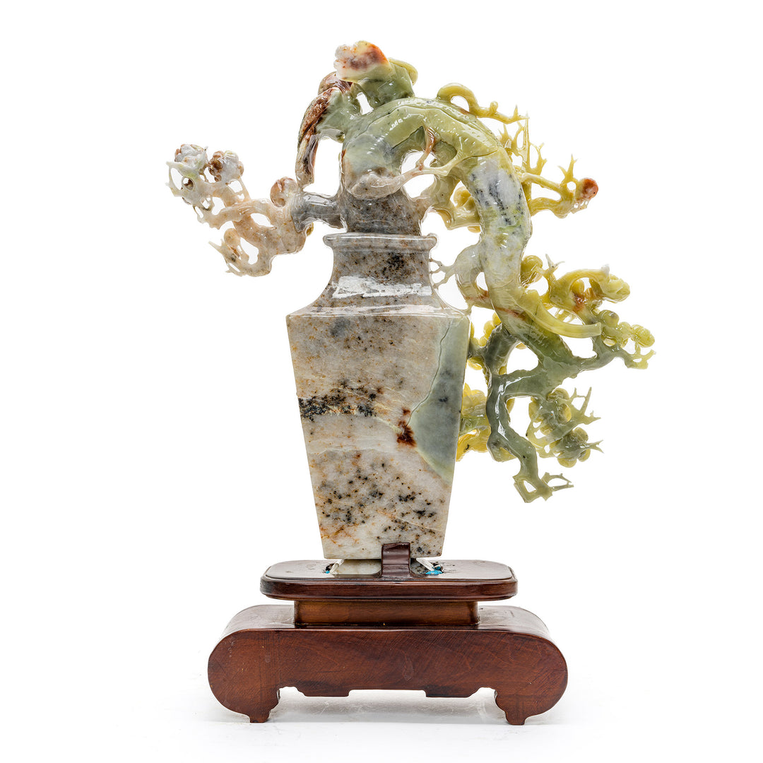 Artisan-crafted agate songbirds atop a floral display.