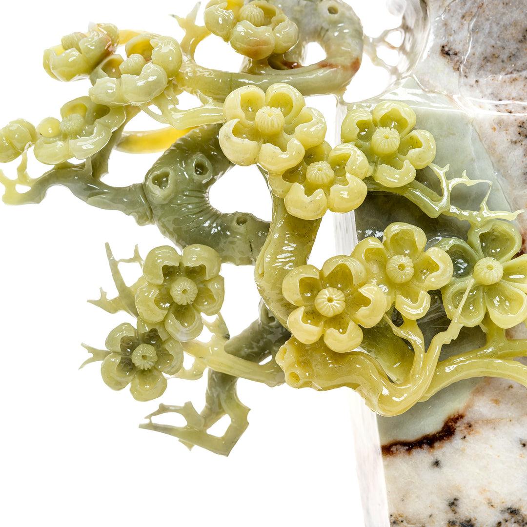 Hand-carved agate birds perched among spring blossoms.