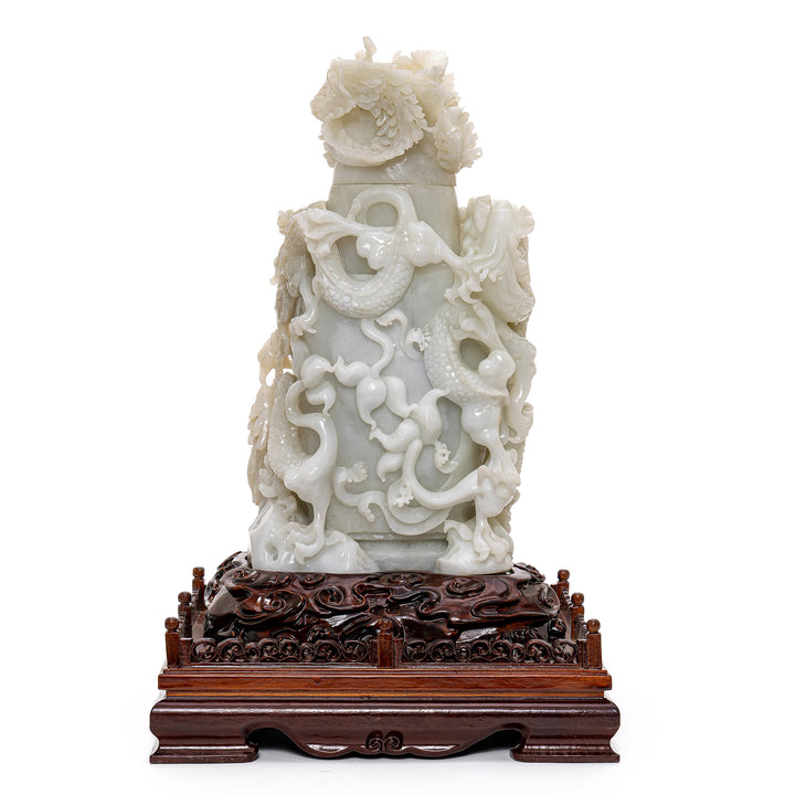 Majestic jade sculpture of dragons on a wooden base.