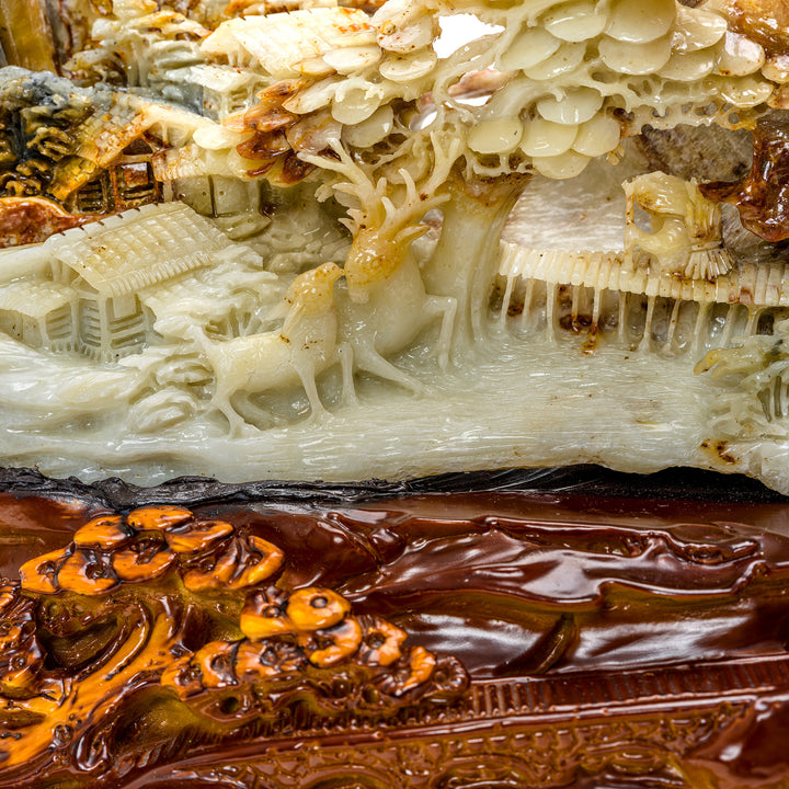 Agate sculpture of a village nestled in mountain foliage