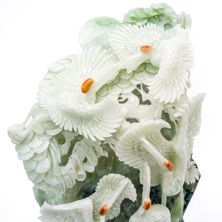 Carved agate cranes on hillside, a harmonious blend of art and nature.