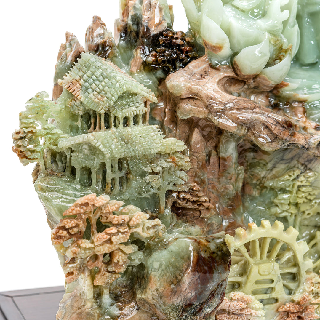 Divine agate carving of Kwan Yin with village scene