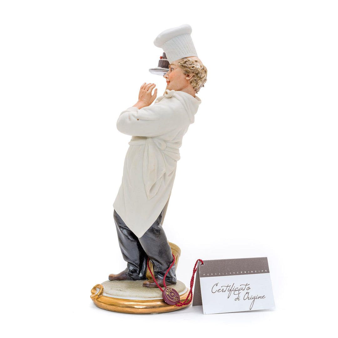 Italian crafted pastry chef with a cake figurine.