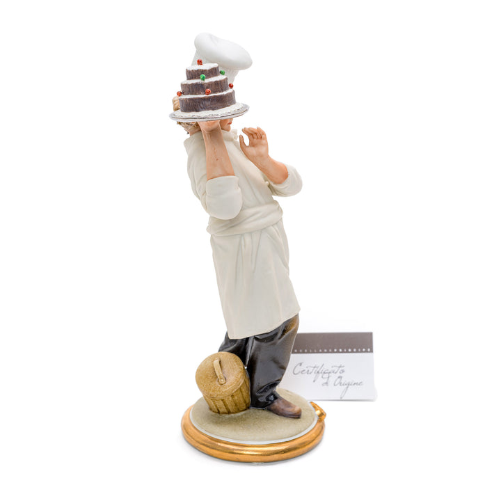 Porcelain figure of a chef presenting a cake by Capodimonte.