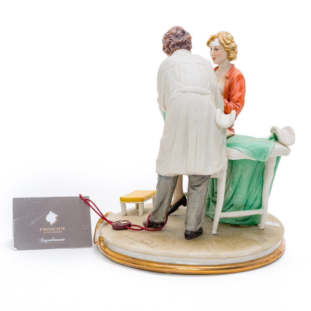 Italian crafted male gynecologist with patient porcelain figurine.