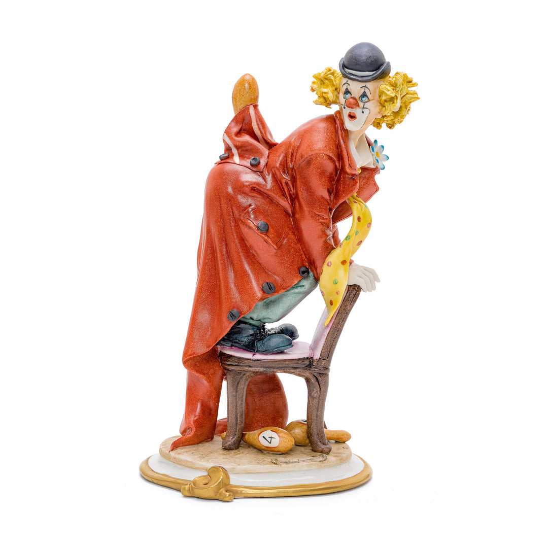 Capodimonte porcelain figurine of a clown with a chair.