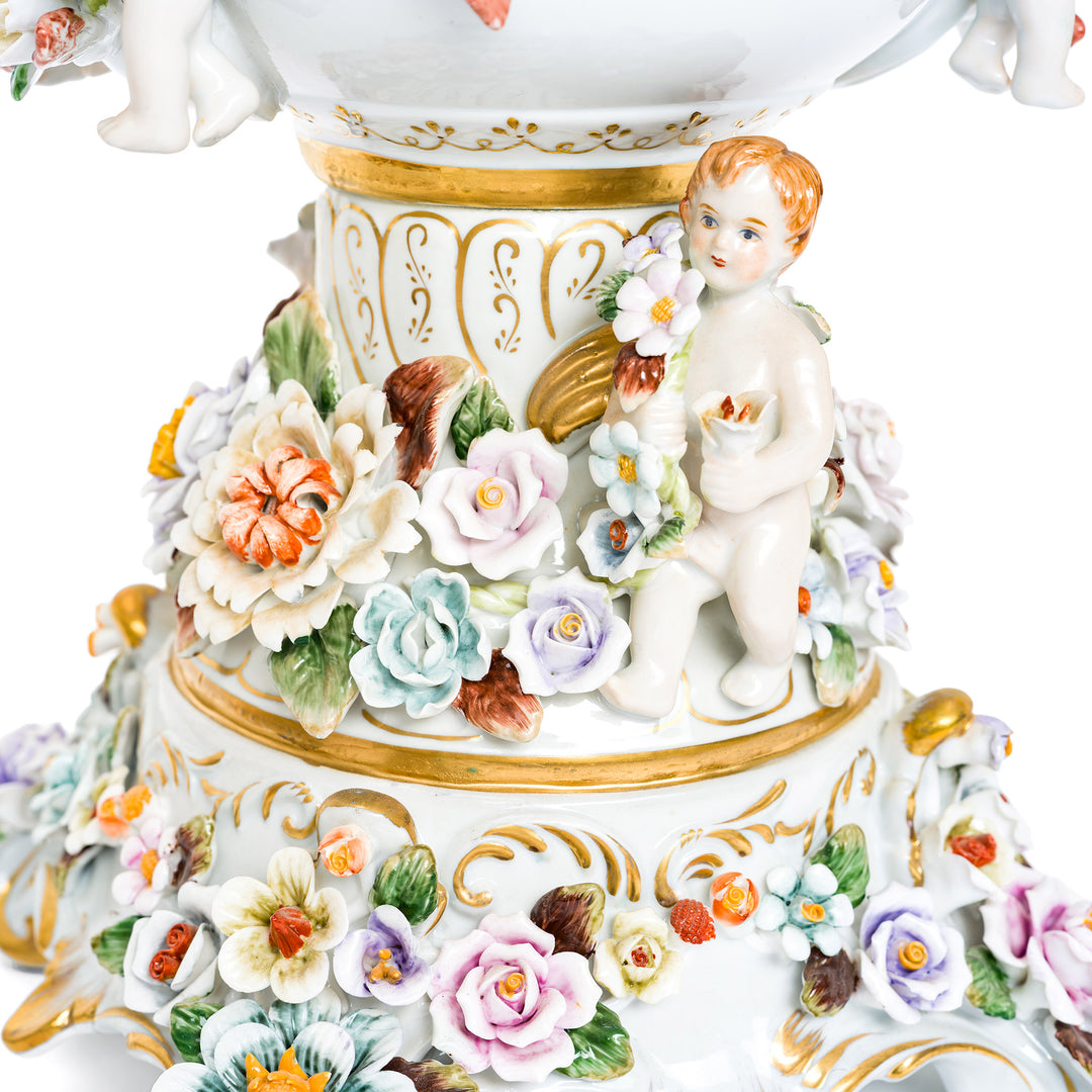 Detailed porcelain vases with sculpted cherubs and floral designs