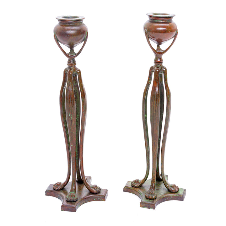 Antique Tiffany candlesticks featuring elongated cats' paw feet and brownish-red patina.