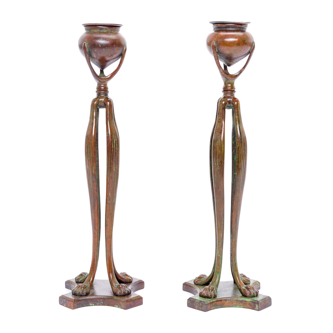 Signed 'Tiffany Studios New York 8682' bronze candlestick pair with green hints.