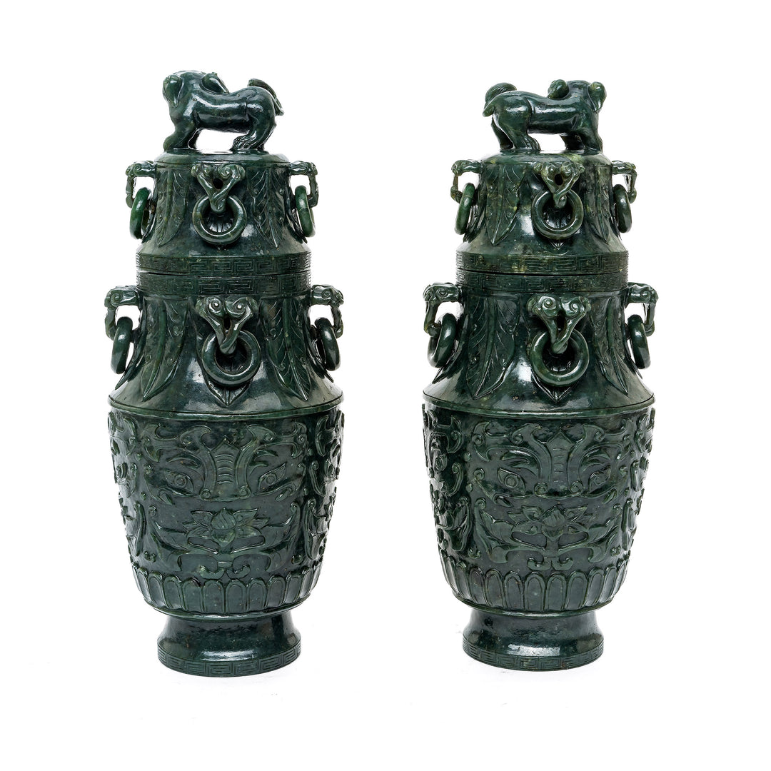 Deep green jade vases with lustrous finish and cultural symbols.