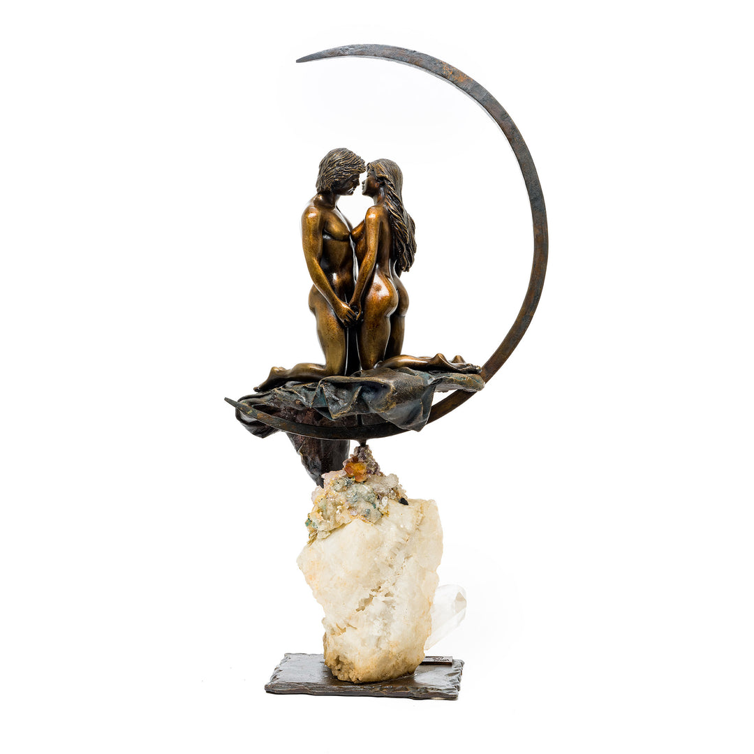Rear view of couple seated in crescent moon on quartz base