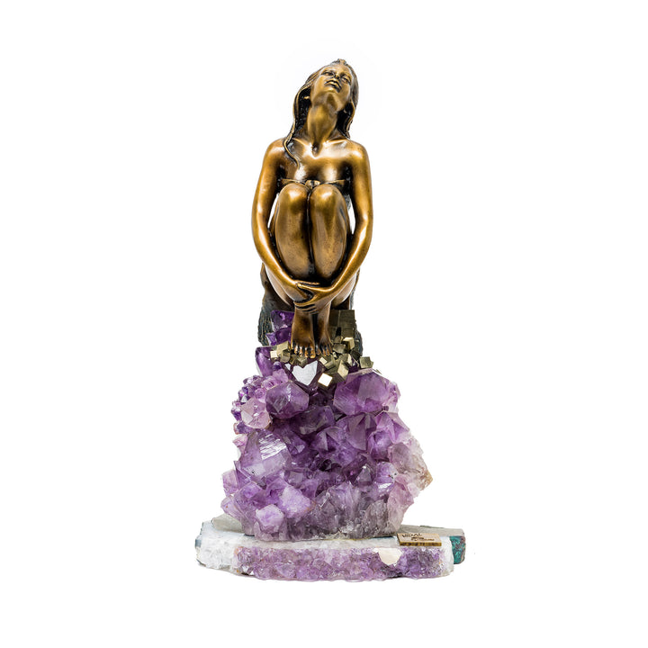 Front view of bronze woman sculpture seated atop amethyst crystals