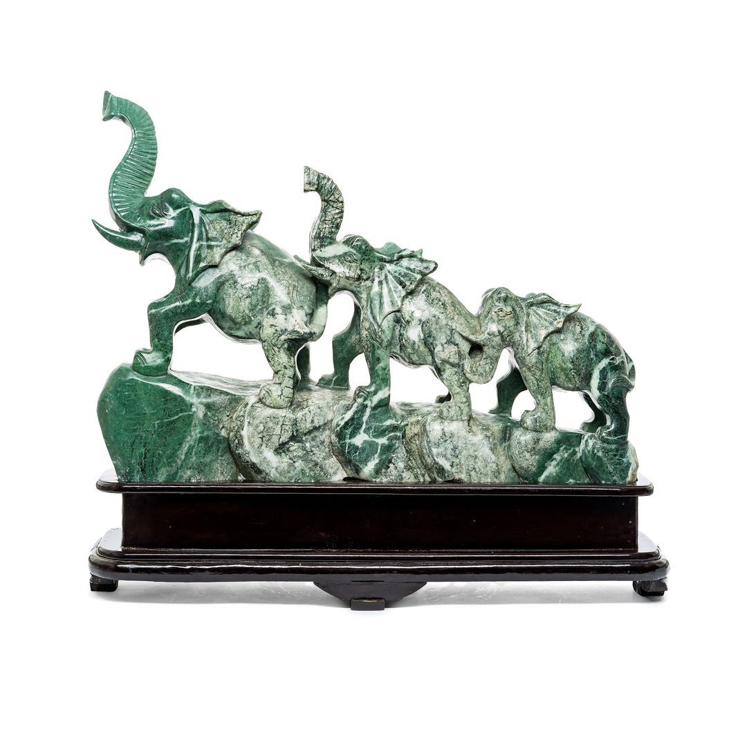 Hand-carved verde marble elephant sculpture on wooden base.