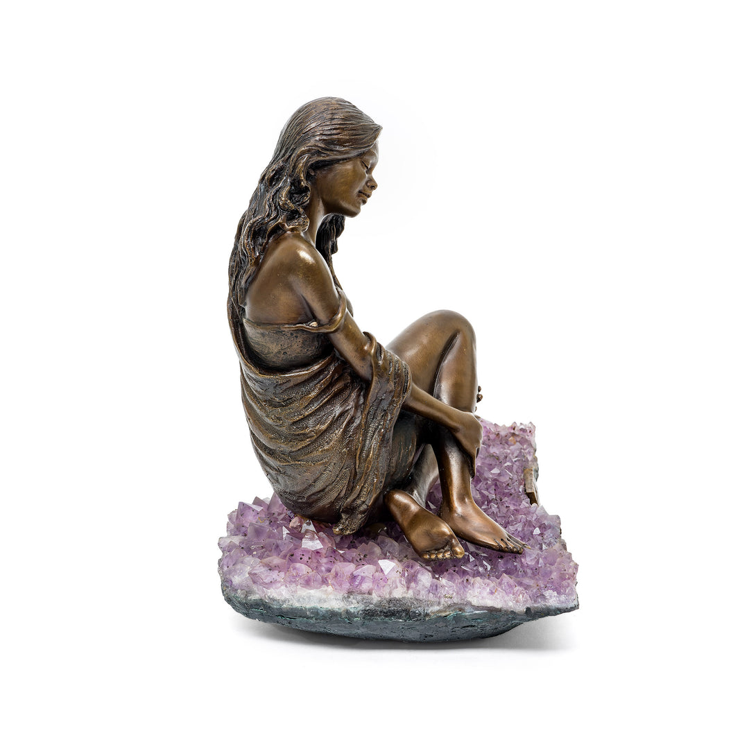 Left side profile of sculpture on sparkling amethyst cluster