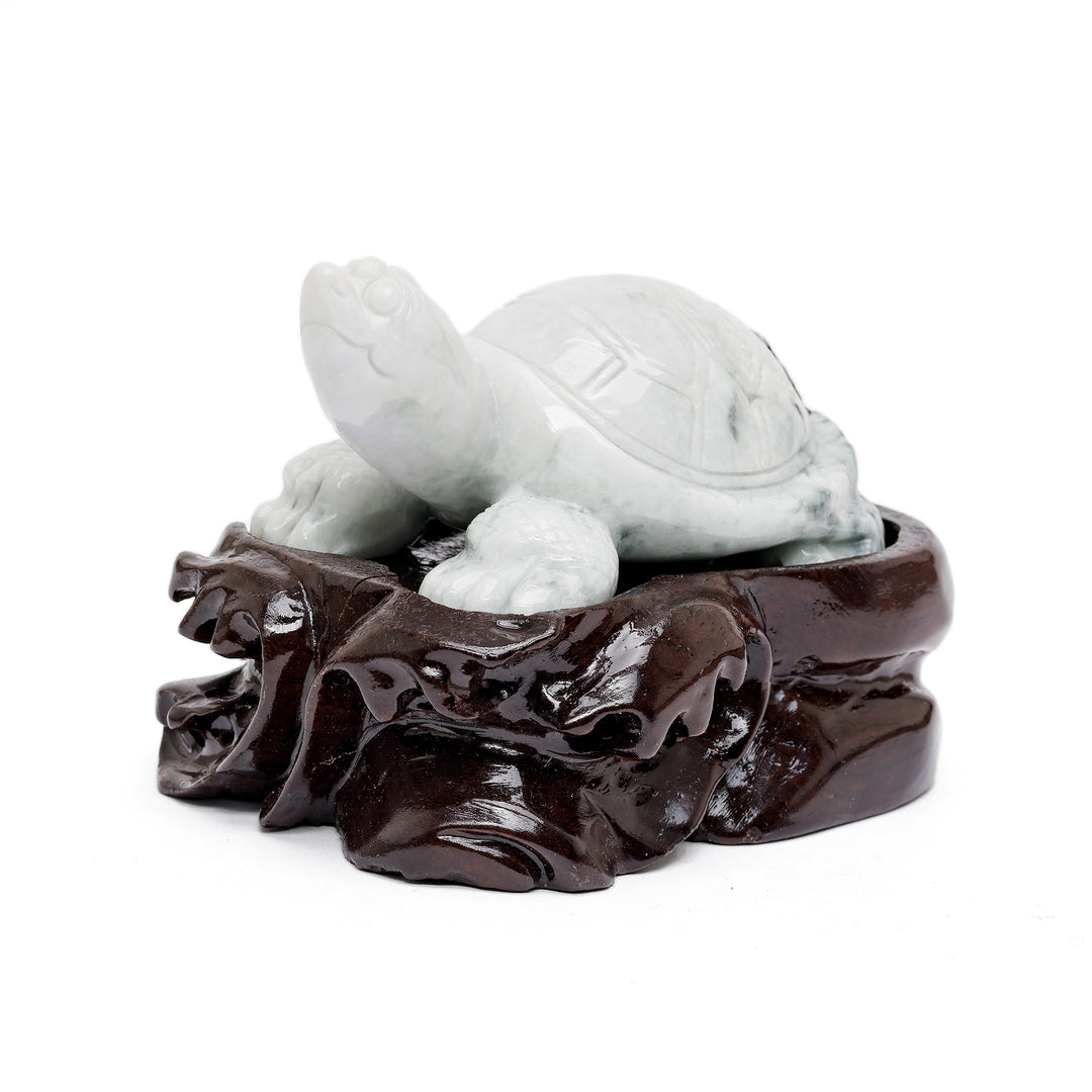 Small jade turtle sculpture on carved wood base
