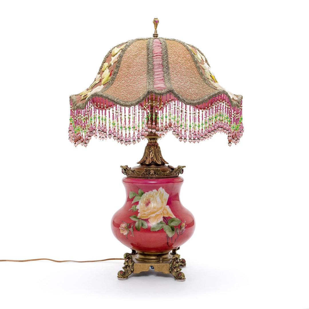 Vintage lamp with floral embroidery and rose design on a bronze base.