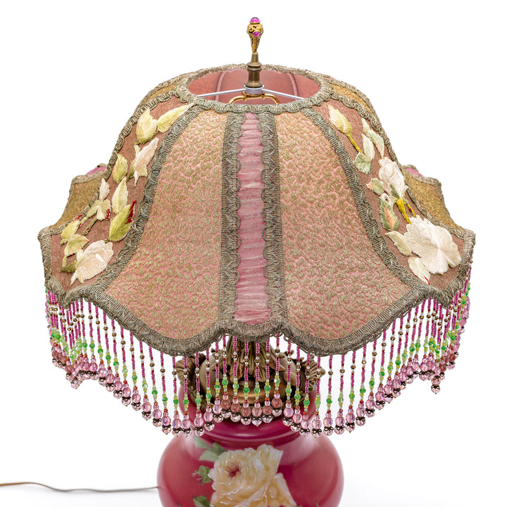Collectible antique lamp with hand-embroidered details and floral motif.