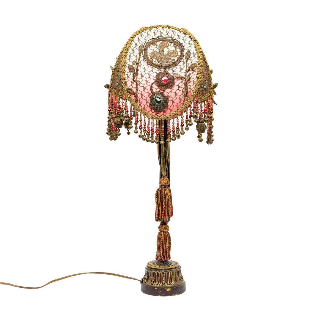 Decorative lamp with intricate design and beads on a white background