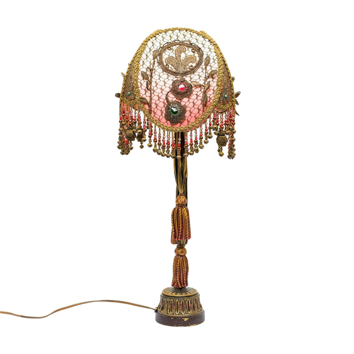 Decorative lamp with intricate design and beads on a white background