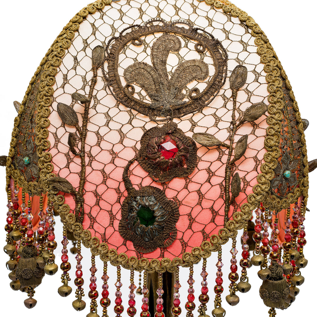 Decorative headpiece with lace, beads, and floral patterns on a white background