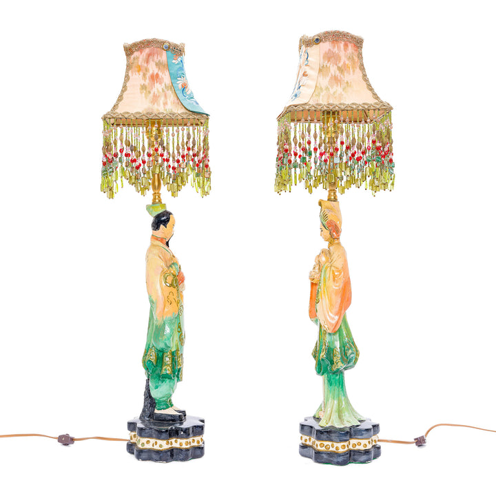 Antique cultural figure lamps with intricate embroidery and beadwork.
