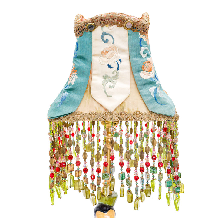 Collectible embroidered lamps with sculpted figures in traditional Asian attire.