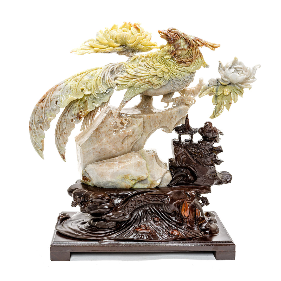 Agate carved Bird of Paradise on a rocky ledge with flowers.