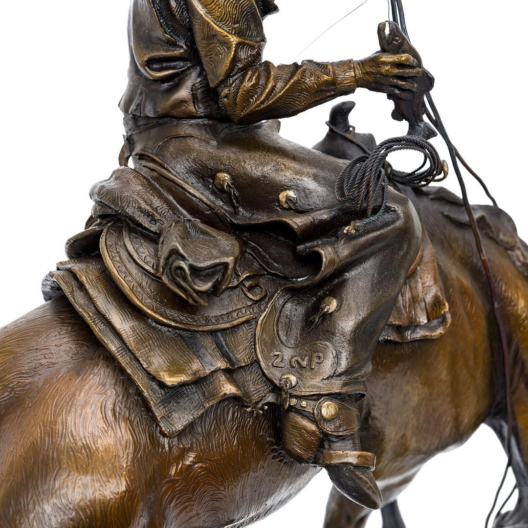 Artistic bronze sculpture of cowboy and horse in motion