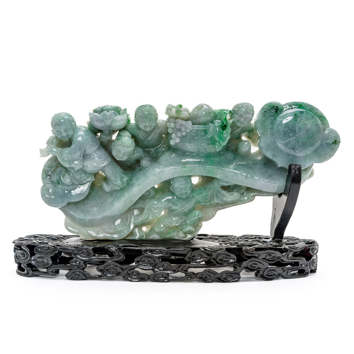 Jade sculpture of children playing on a scepter with apple and spinach hues.
