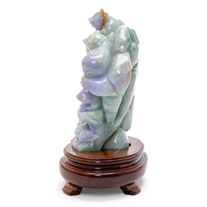 Intricately carved jade artwork depicting multiple pigs frolicking on a mountain.