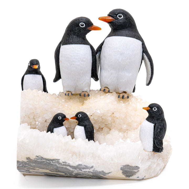 Hand-carved obsidian penguin family on a quartz ice sculpture