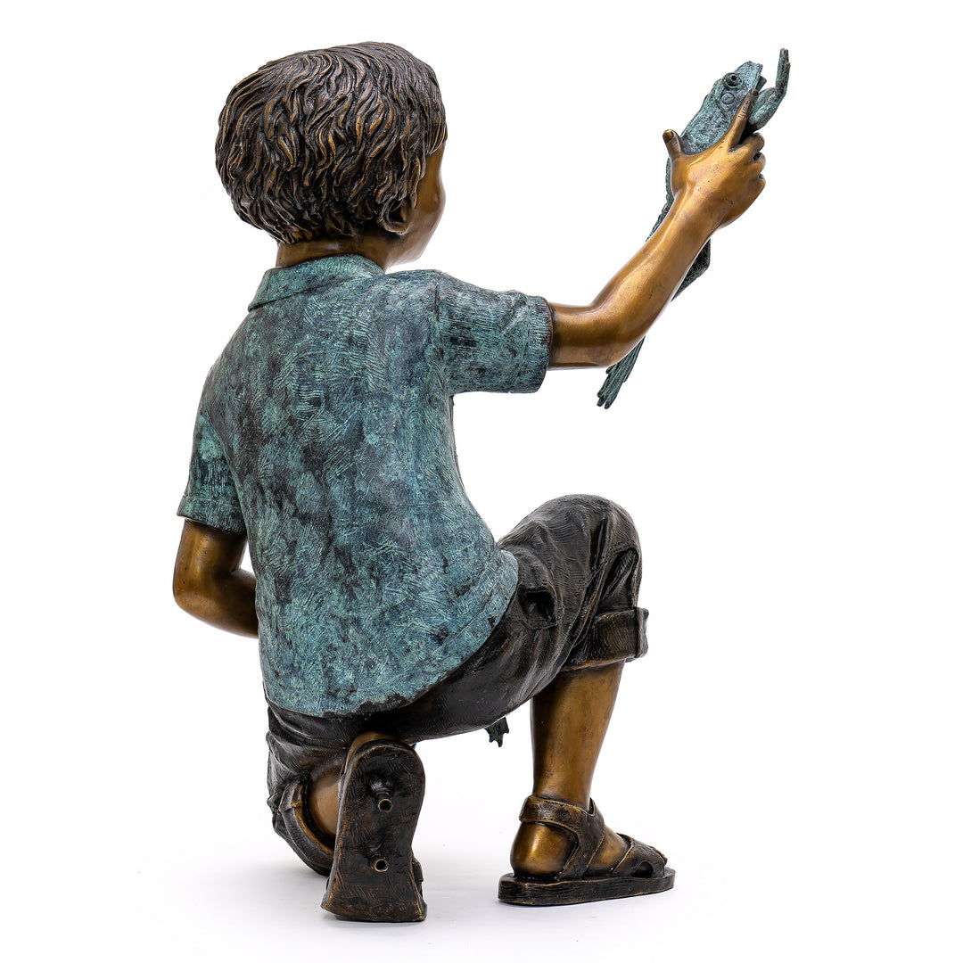 Bronze art depicting a child’s enchantment with frogs.