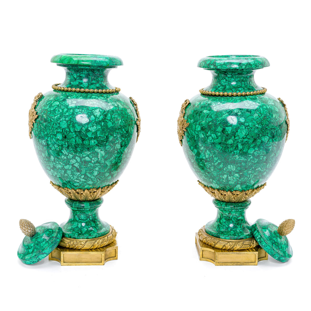 Regal 19th-century malachite vases adorned with luxurious doré mounts.