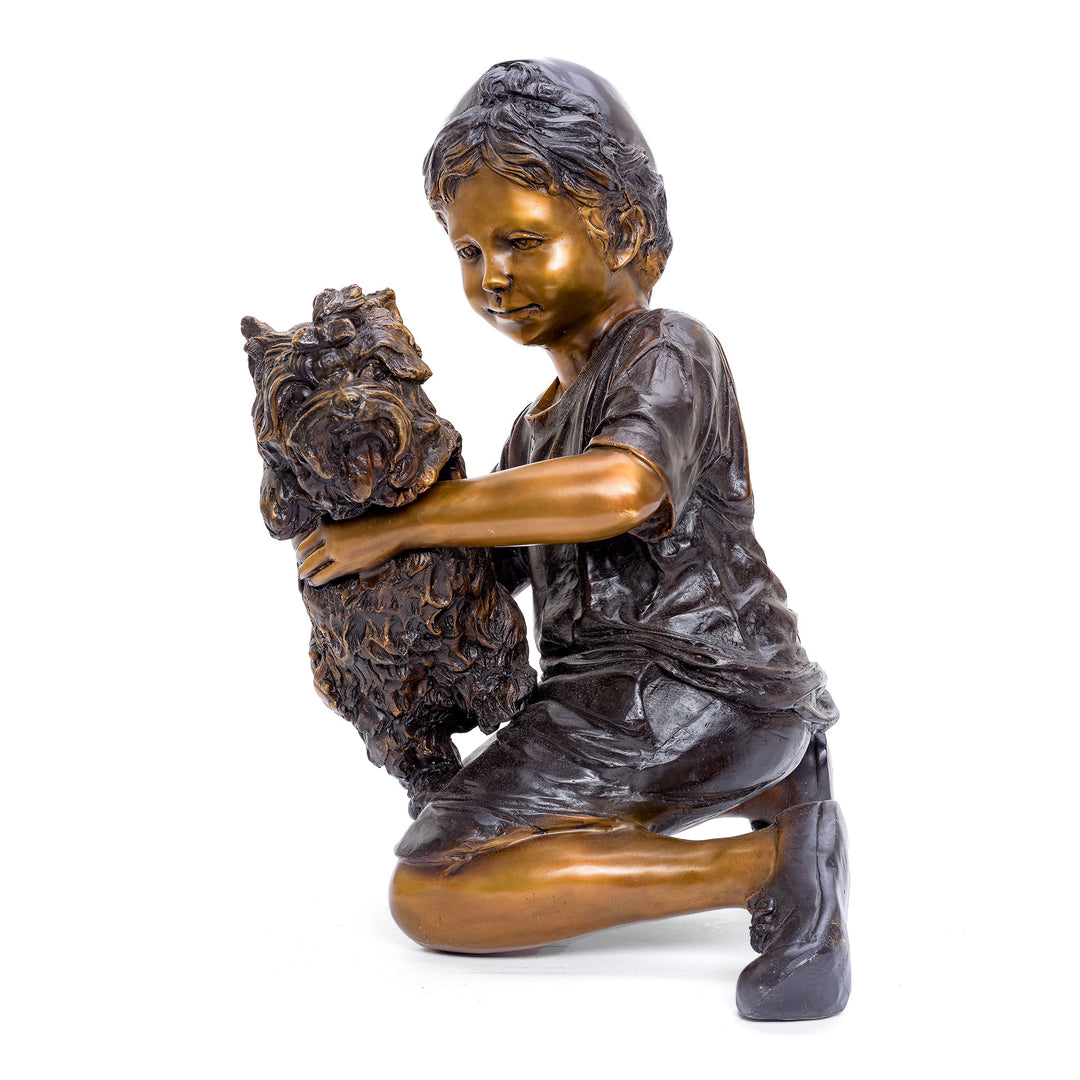 Bronze sculpture of boy holding a Yorkie with care.