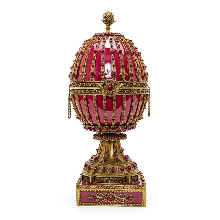 Red porcelain egg with doré bronze accents and cabochons on a pedestal base.