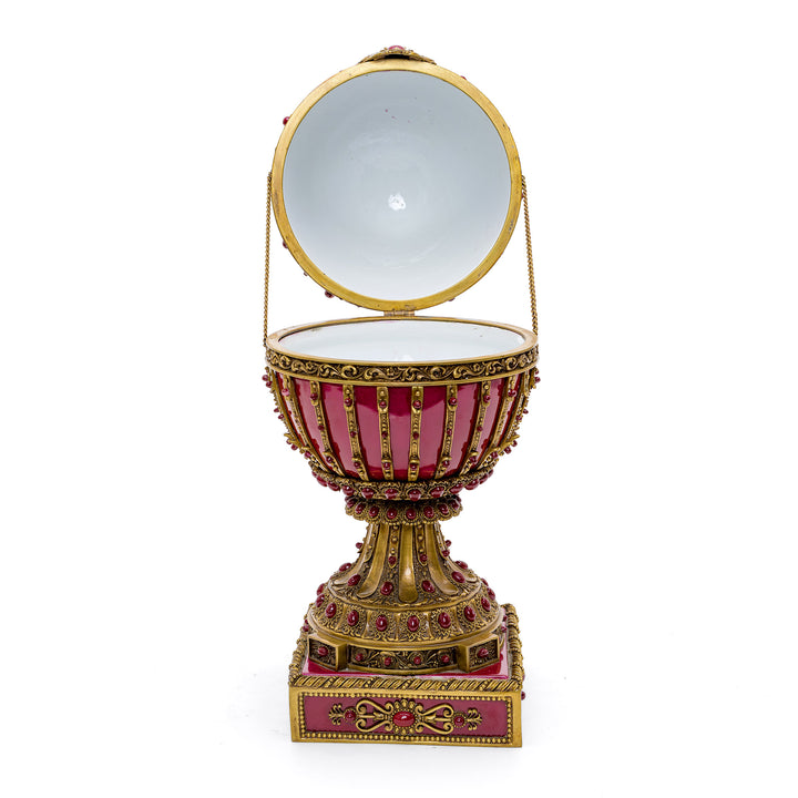 Luxurious decorative egg with gleaming gold bronze and red porcelain.