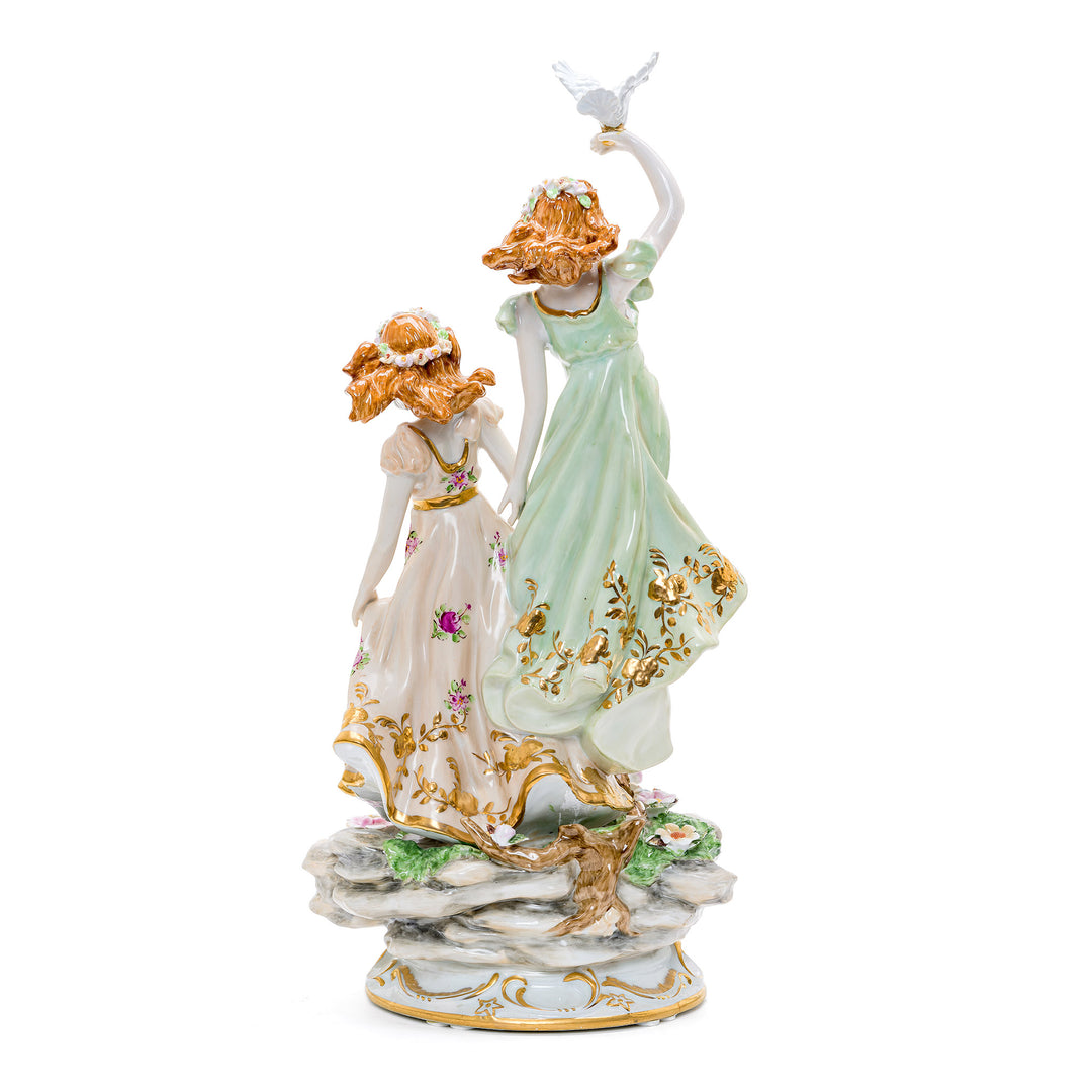Artistic porcelain representation of peaceful interaction with doves in a garden.