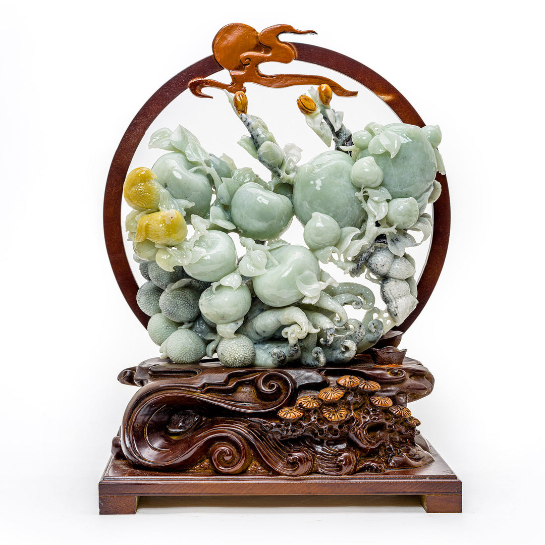 Hand-carved agate sculpture of a bushel of peaches on a wooden base.