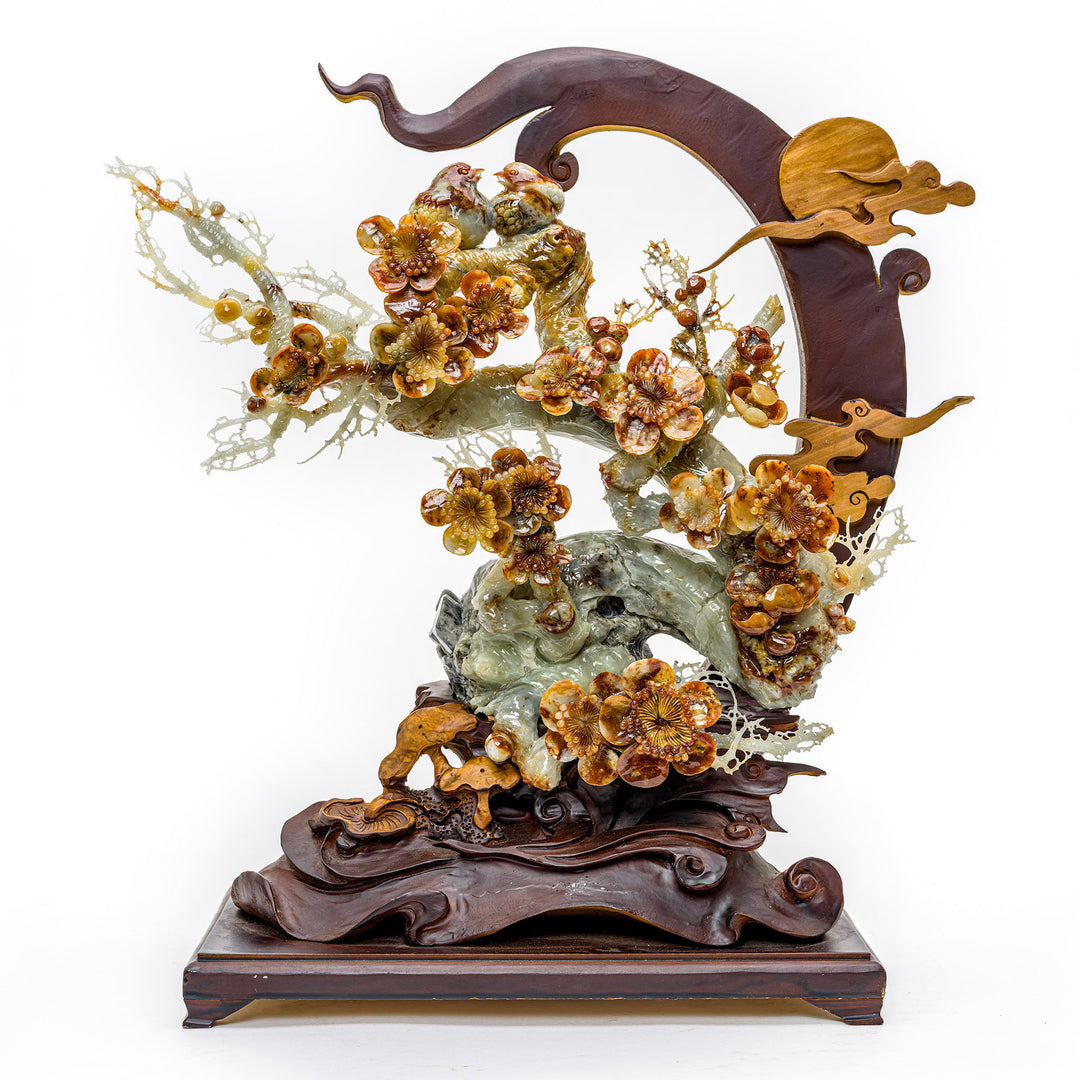 Hand-carved agate sculpture of a blooming peony branch on a wooden stand.
