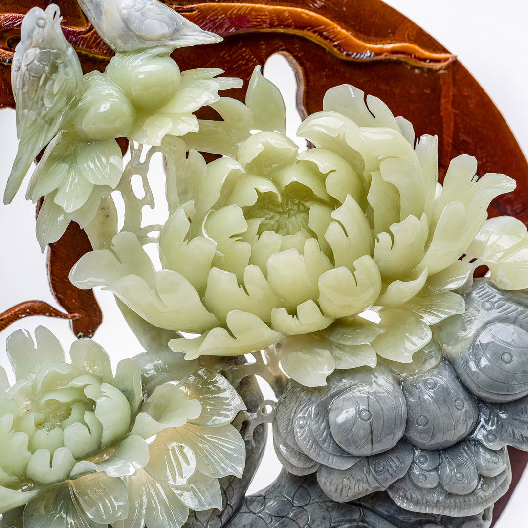 Floral and avian duo carved in agate, set against a backdrop of rich wood.