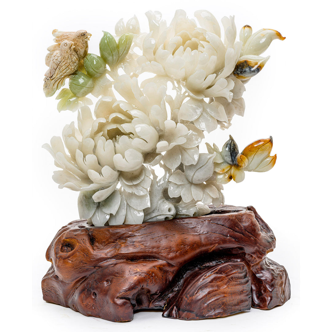 Hand-carved agate sculpture of blooming peonies with a perched bird on a wood base.