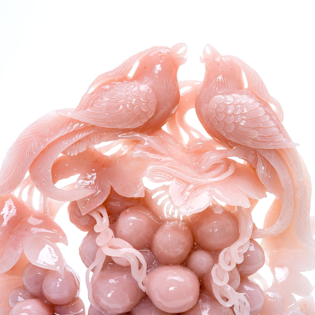 Harmonious phoenix birds in rose quartz, perched atop a carved cluster of grapes