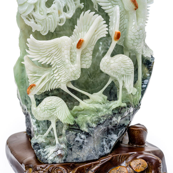 Serene agate sculpture depicting a group of cranes on a hill.