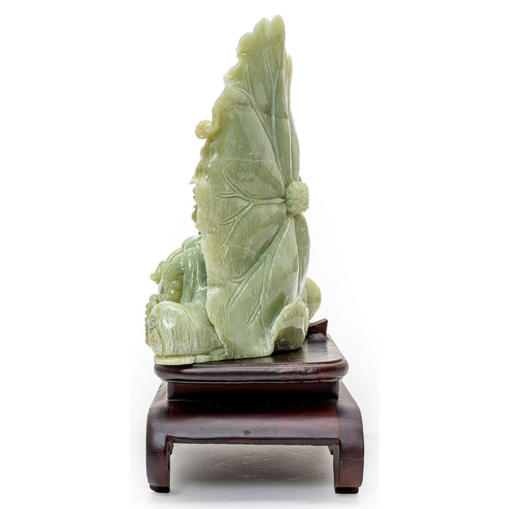 Agate carving of Buddha seated in serenity by a large lotus flower, symbolizing enlightenment.