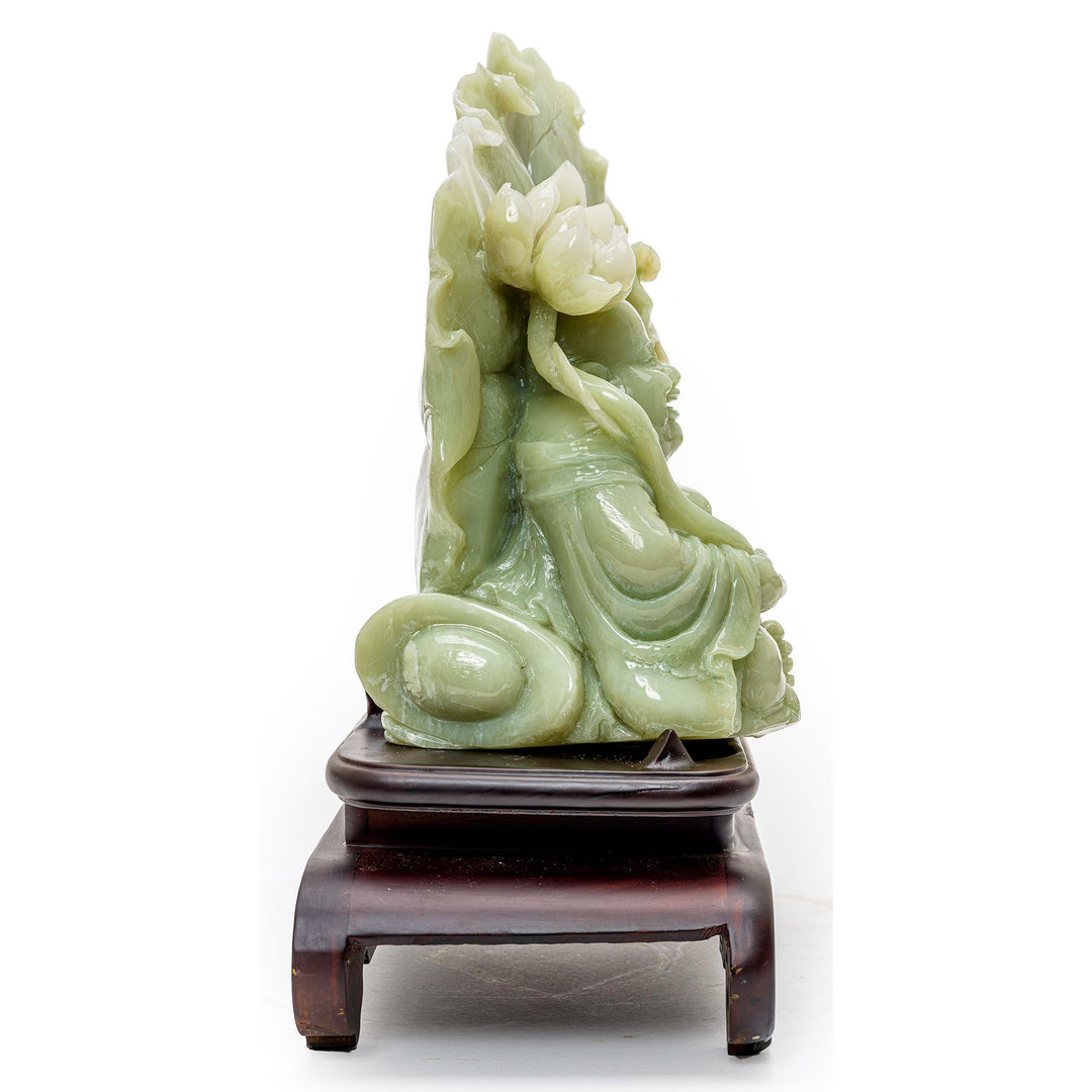 Seated Buddha holding scepter, carved in agate with a backdrop of a lotus flower.
